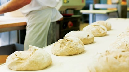 Työntekijät luovat elintarvikkeita taikinasta